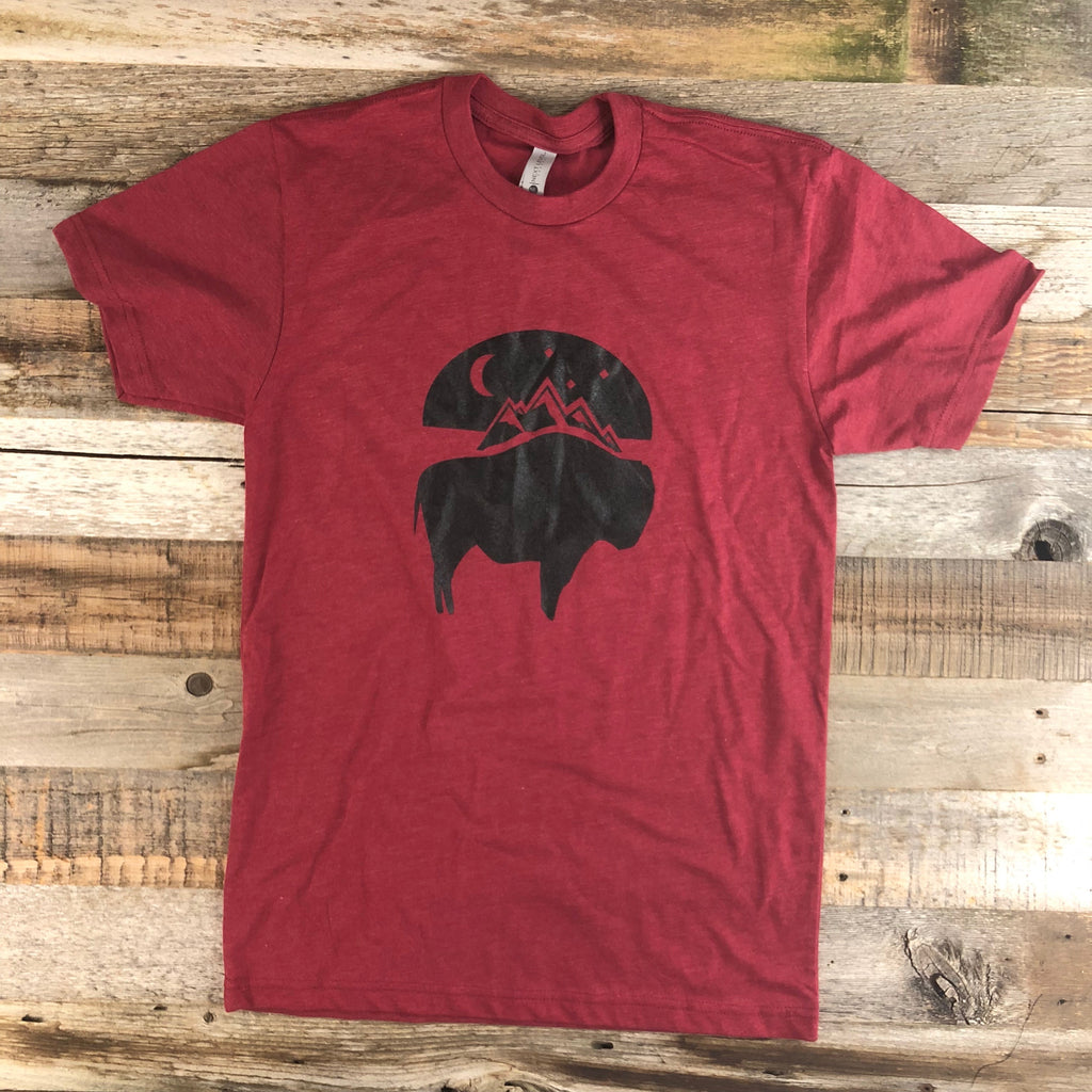 The New Bison Moon is a modern twist on our long time iconic T-shirt design from WyoMade Apparel! The Bison represents freedom and as a staple of Wyoming's open spaces. This Cardinal Red T-shirt is sure to appease your desire to roam free.  Be a part of the herd in a comfy dual blend Bison Moon T-Shirt deigned for both men and women.   WyoMade offers sizes ranging from XS- 2XL! 