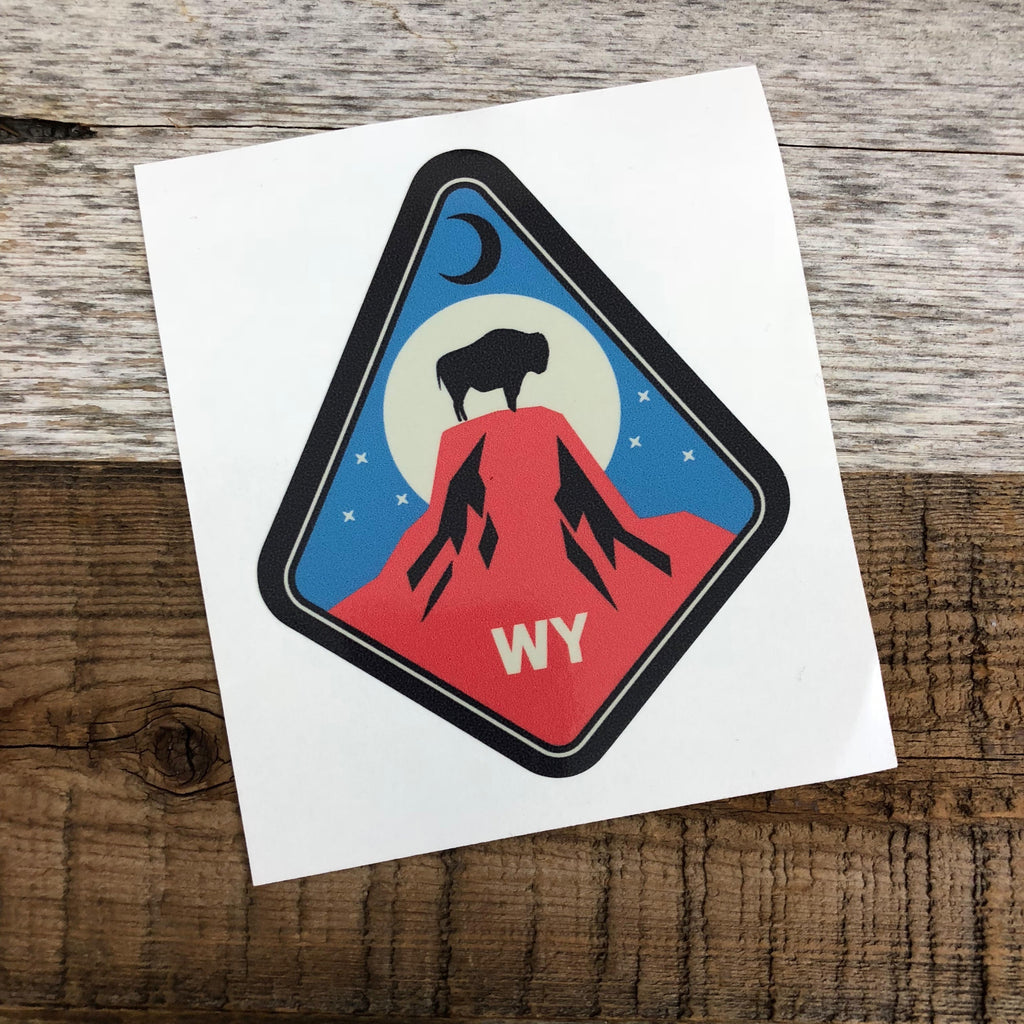 The New Bison Moon is a modern twist on our long time iconic design from WyoMade!   The Bison represents freedom and is a staple of Wyoming's open spaces. This sticker is sure to appease your desire to roam free.  Set atop the Devils Tower National Monument, you'll be a part of the herd with the Tower Bison Moon Sticker from Wyomade.     Size:  3.3" x 3"